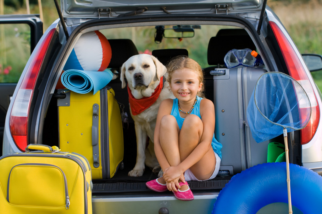 A kid and her dog ready to go camping